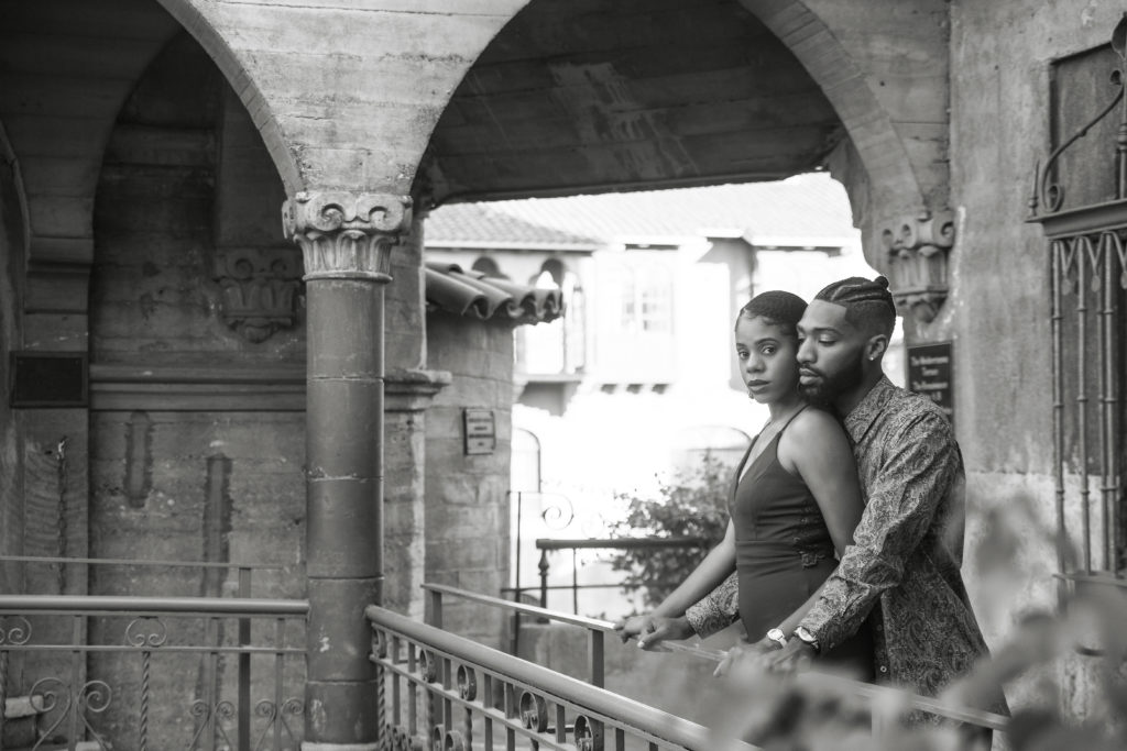 Engagement session standing by rail at mission inn