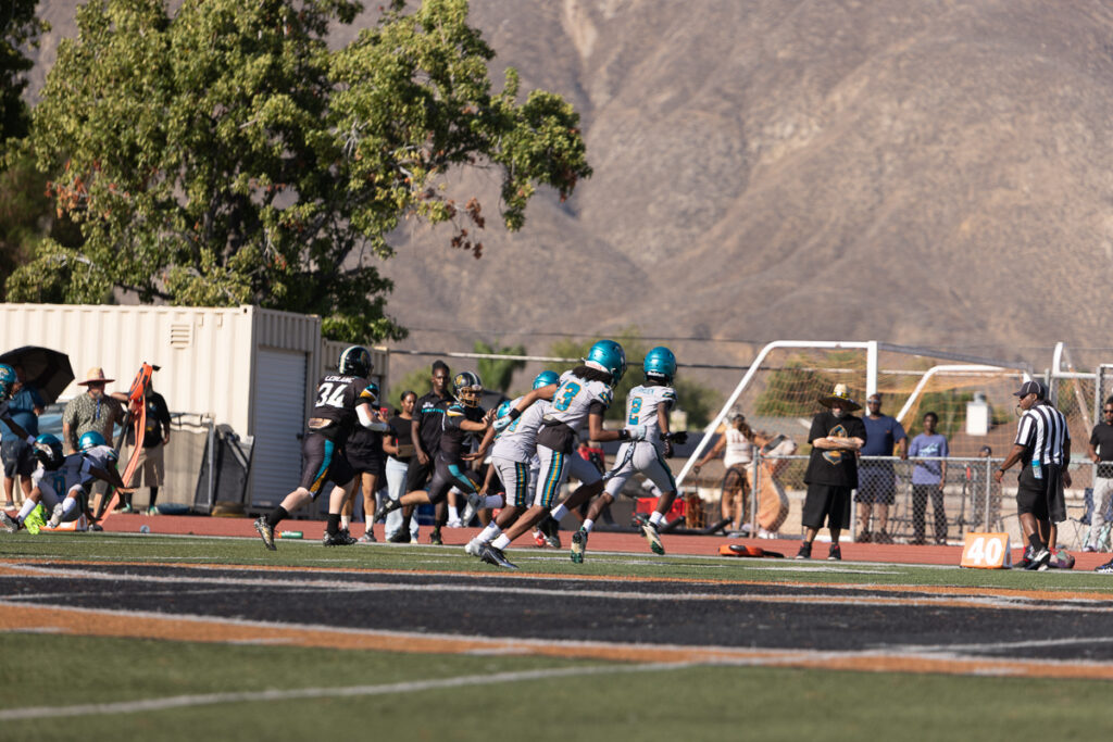 Riverside family photographer action shot of Inland Immortals 12U football player making a tackle"
"Hemet family photographer capturing 13U Inland Immortals football game"
"Inland Immortals cheer squad sideline photo by Riverside family photographer"