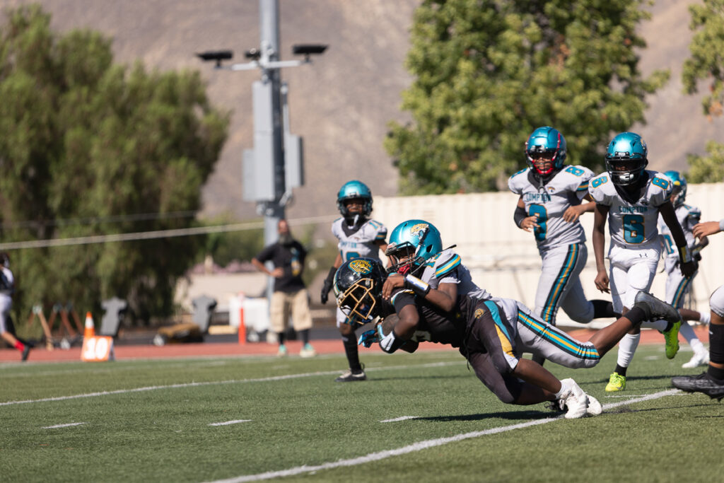 Riverside family photographer action shot of Inland Immortals 12U football player making a tackle"
"Hemet family photographer capturing 13U Inland Immortals football game"
"Inland Immortals cheer squad sideline photo by Riverside family photographer"