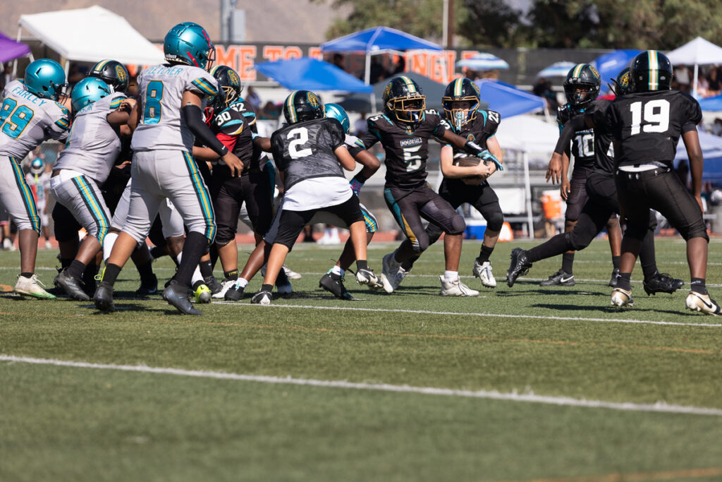 Riverside family photographer action shot of Inland Immortals 12U football player making a tackle"
"Hemet family photographer capturing 13U Inland Immortals football game"
"Inland Immortals cheer squad sideline photo by Riverside family photographer"